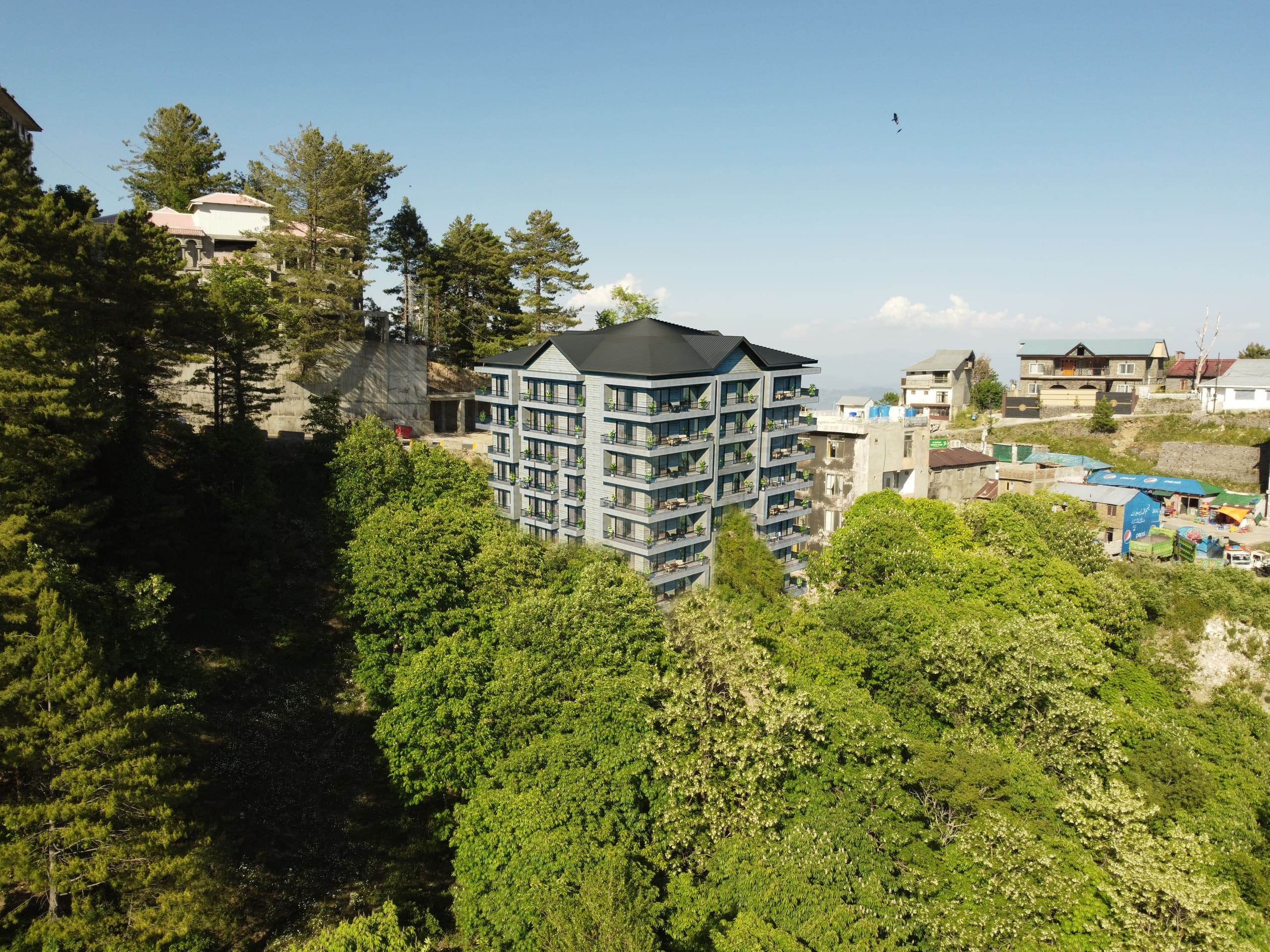 Skyline Terrace rising above the pine forest in Khaira Gali, with the town and hills behind